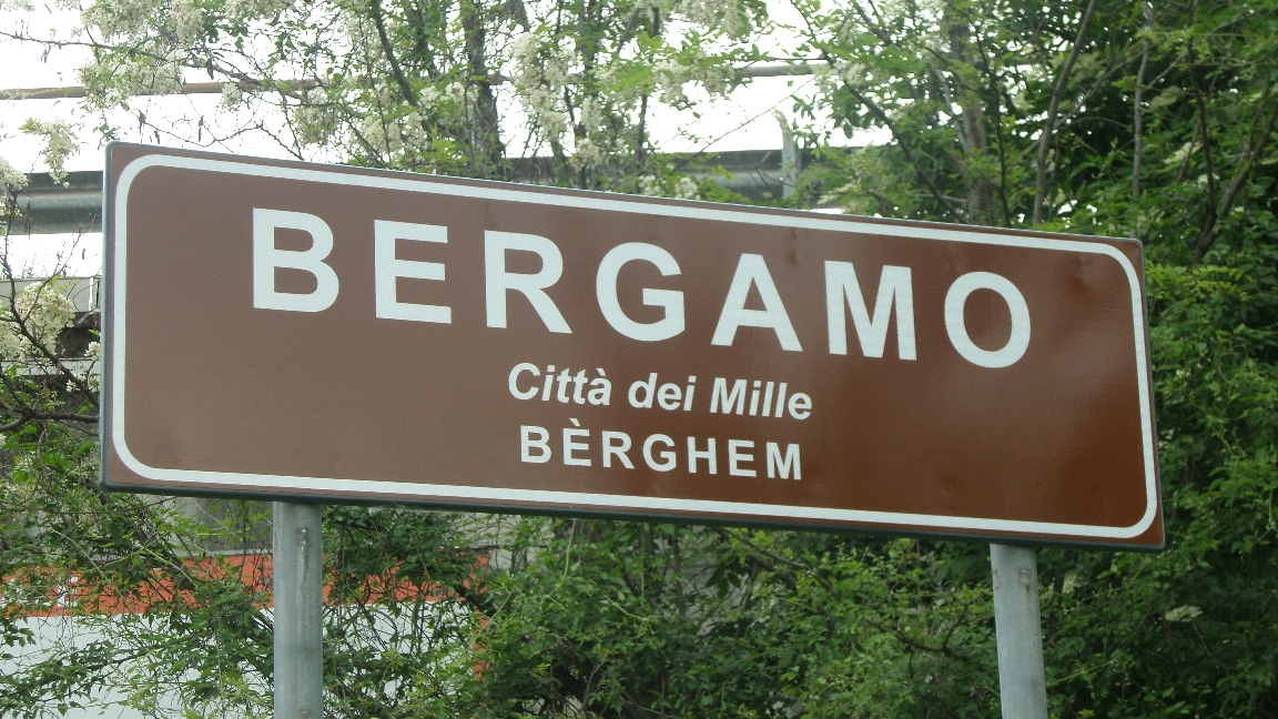 Cartello Bergamo, via stemmi e benvenuto. Resta la scritta “Bèrghem”